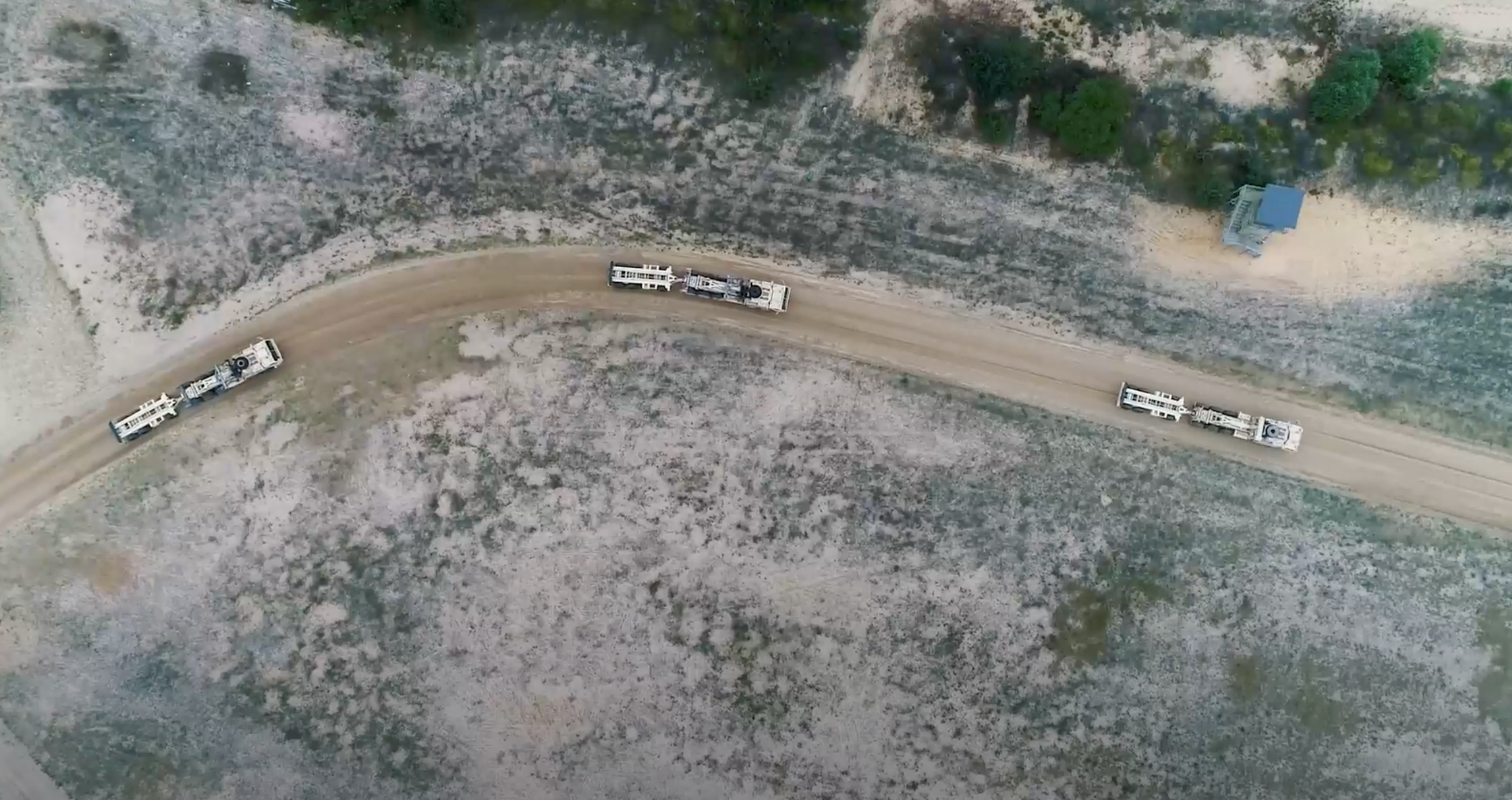 Sky view of trucks driving on curved road