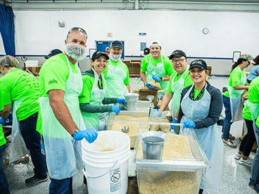 Group of people volunteering at Oshkosh Corporation's Feed the Body, Feed the Soul event