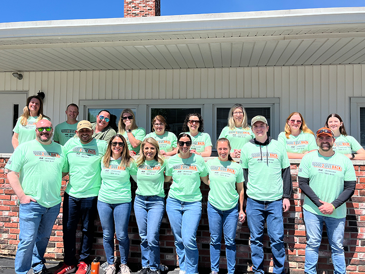 Team members smiling outside building