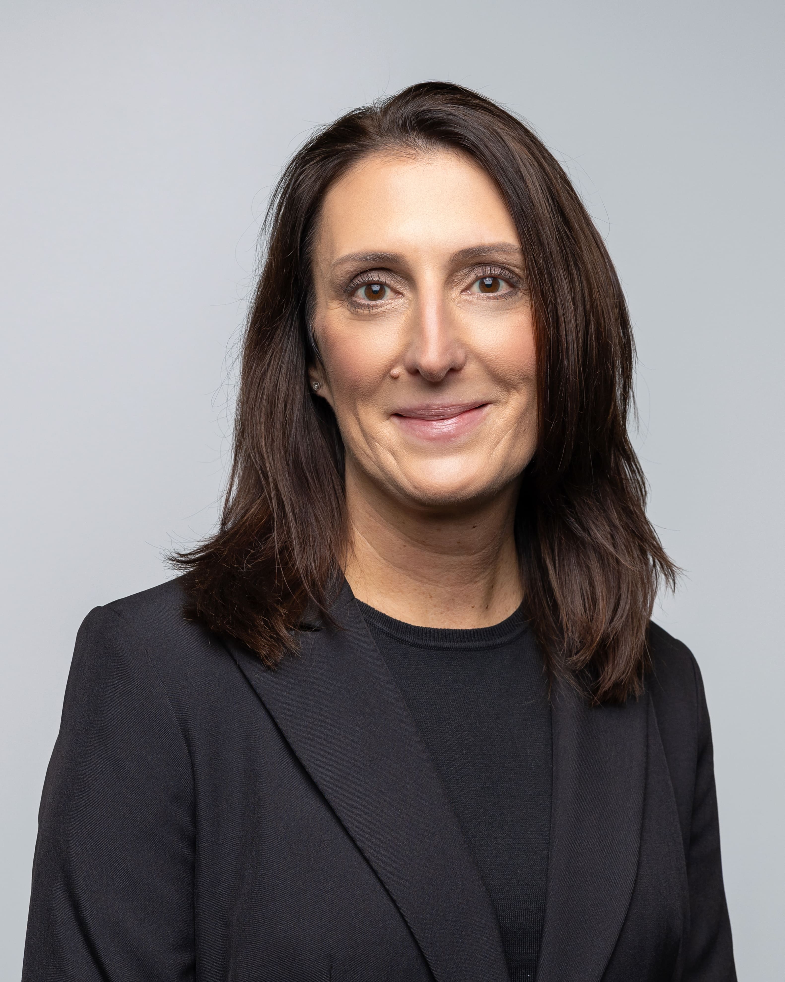 Headshot of Jackie Nystrom wearing a black suit coat and black top